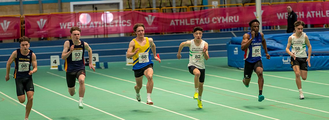 Junior boys athletes competing in the 60m sprint indoors.