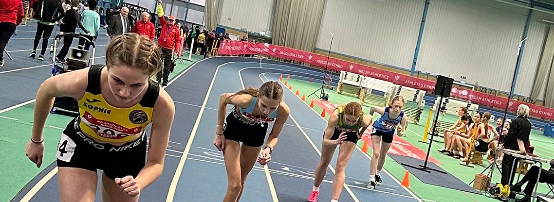 Junior girls athletes lining up at the start of a race.